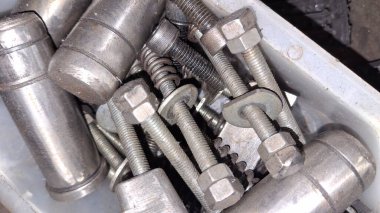 Beyaz arkaplanda metal fındık ve cıvatalar.