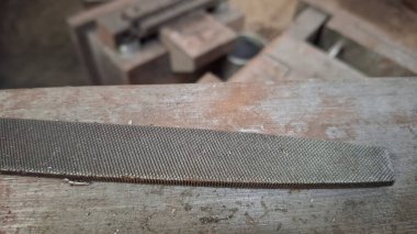 Eski binanın arka planında paslı metal bir boru var.