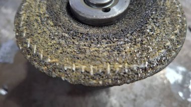 Yüzeyde bulanık bir arka planı olan metal bir vidanın yakın çekimi.