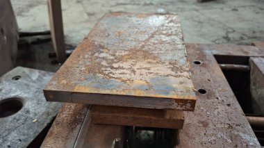 Ahşap masalı paslı metal bir plaka.