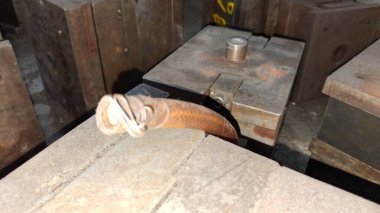 Eski paslı, saplı metal bir boru.