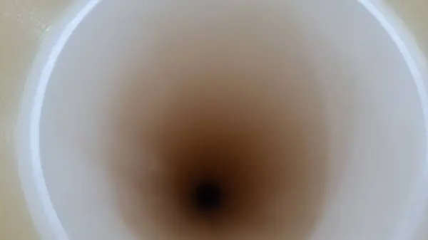 Beyaz yüzeydeki bir fincan kahvenin dikey çekimi.