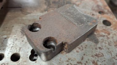 Masanın üzerinde eski paslı demir var.