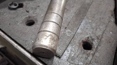 Eski paslı, saplı metal bir boru.