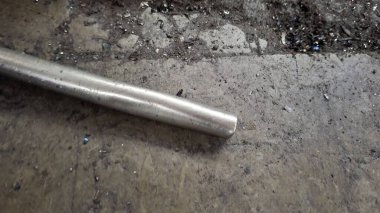 Metal bir boruyla ahşap bir masaya yakın.