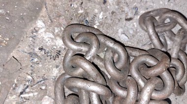Bir sürü farklı boyutlarda paslı metal zincir.