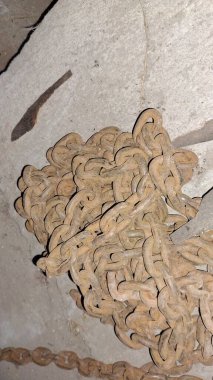 Duvarın arka planında eski metal zincir