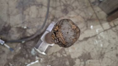 Ahşap arka planda paslı metal bir boru.