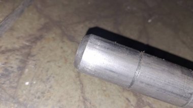 Ahşap arka planda paslı metal bir boru.