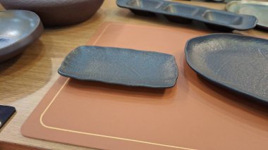 Boş bir tabak, bir kaşık ve tahta bir masada bir bıçak.