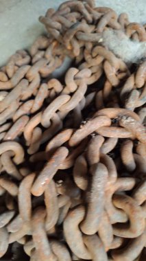 Beyaz arka planda paslı bir zincir yığını