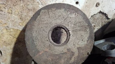 Evin arka planında paslı metal bir boru var.