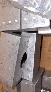 Metal odun parçasını kesiyor.