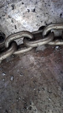 Eski duvarın arka planında paslı metal zincir