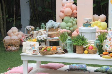 Yaratıcı cinsiyet ayrımı olmayan bebek partisi ya da bahçede doğum günü süsü. Balonlarla kurulmuş bohem tarzı bir açık hava etkinliği. Beyaz kremalı şeftali rengi balon kemer takımı.