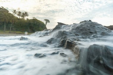 Deniz burnu, mercan kayaları ve Endonezya 'daki Sawarna Sahili' ndeki pamuk gibi yumuşak görünen deniz suyuyla çok güzeldir. Yavaş deklanşör hızı etkisi