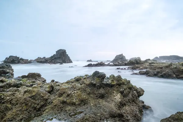 stock image seascape is very beautiful with coral rocks and sea water that looks very soft like cotton at Sawarna Beach, Indonesia. slow shutter speed effect