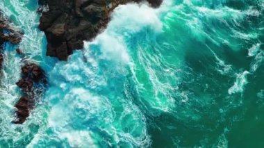 Büyük dalgaların kayalıklara çarptığı havadan kuşbakışı deniz kıyısı. Güneşli yaz günlerinde güzel dalgalar yüzeye çıkar. inanılmaz deniz manzarası