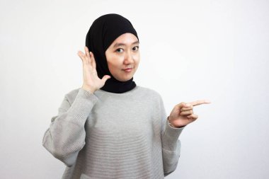 Yan tarafa uzanan tesettürlü mutlu genç Asyalı kadın. beyaz arkaplanda izole