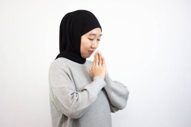 Müslüman bir kız dua ediyor. Beyaz Arkaplanda İzole Edilmiş