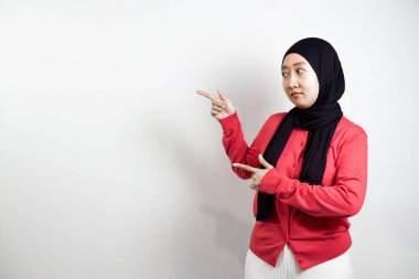 Yan tarafa uzanan tesettürlü mutlu genç Asyalı kadın. beyaz arkaplanda izole