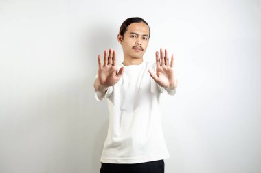 Beyaz tişört giyen genç bir adam. Ellerinle hareket etme. Kollarını kavuşturdu. Öyle bir şey yok. Beyaz arkaplanda izole edilmiş işaret