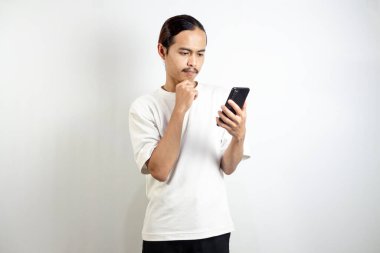 Asyalı adam telefonu tutuyor. Düşünceli bir ifadeyle. beyaz arkaplanda izole