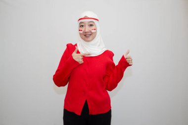 Beyaz tesettürlü, kırmızı gömlekli bir kadın. Endonezya 'nın bağımsızlık gününü kutluyoruz. Sevinçle. Beyaz arkaplanda izolasyon.