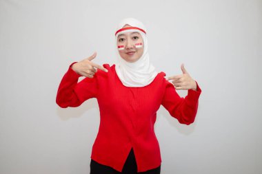 Beyaz tesettürlü, kırmızı kazaklı bir kadın. Endonezya 'nın bağımsızlık gününü kutluyoruz. Aşağıya doğru. Beyaz arkaplanda izolasyon.