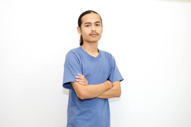 Koyu mavi tişört giyen gülümseyen Asyalı adam kollarını öne doğru kavuşturmuş duruyor. beyaz arkaplanda izole