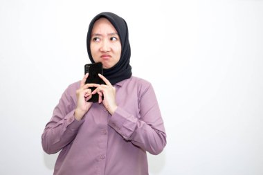 Asyalı, Endonezyalı mor elbiseler giyen ve kızgın ve üzgün ifadeli siyah başörtüsü takan kadının elleri kaşınmak istiyor. beyaz arkaplanda izole