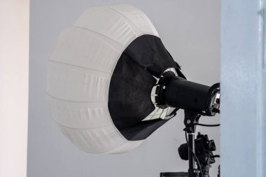 Bir fotoğraf stüdyosuna yerleştirilmiş güzel bir fener, yumuşak ışık saçıyor ve yaratıcı fotoğraf çekimleri ve stüdyo oturumları için sıcak ve davetkar bir atmosfer yaratıyor.