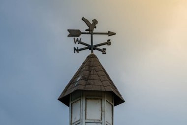 Göz kamaştırıcı bir arka planı ve ışıldayan güneş ışınlarıyla sergilenen bir rüzgar değirmeni. Bu görüntü, rüzgâr gülünün, sakin bir açık hava ortamındaki güzelliğini yakalar.