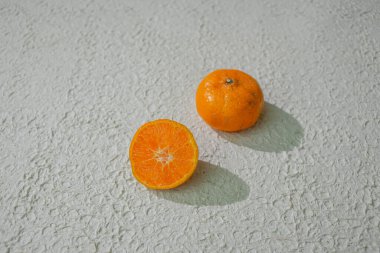 Dilimlenmiş bir portakal sulu içini gösterir, beyaz arka planda izole edilmiş, tazeliği, sağlığı ve doğal narenciyeyi sembolize eder.