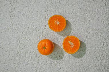 Dilimlenmiş bir portakal sulu içini gösterir, beyaz arka planda izole edilmiş, tazeliği, sağlığı ve doğal narenciyeyi sembolize eder.