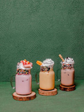 Lezzetli çilek, Mocha ve krem şantili çikolatalı milkshake, yuvarlak ahşap bir bardak altında zarif bir şekilde servis edilmiş..