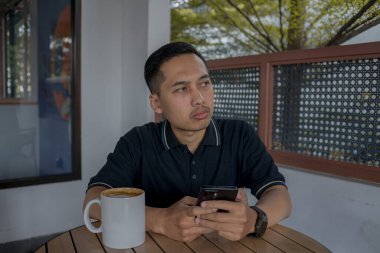 Bir adam bir kafede durup düşünürken ve bakarken sessiz bir düşünce ve düşünce anının tadını çıkarıyor..