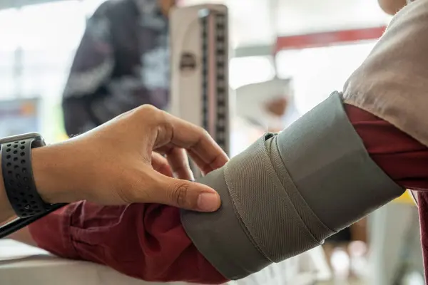 Mesane ya da kelepçe yakın çekim kan basıncı monitörüne. Klinikte kan basıncını ölçen birinin resmi.