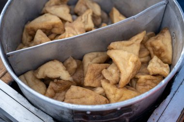 Metal bir kabın içinde kızarmış tofu parçaları.