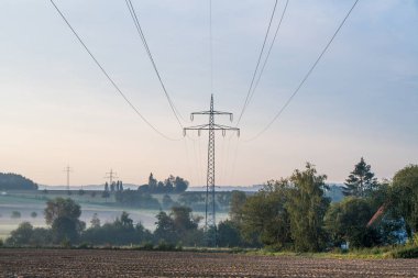 Sabahın erken saatlerinde sisli güzel bir arazide elektrik hattı.