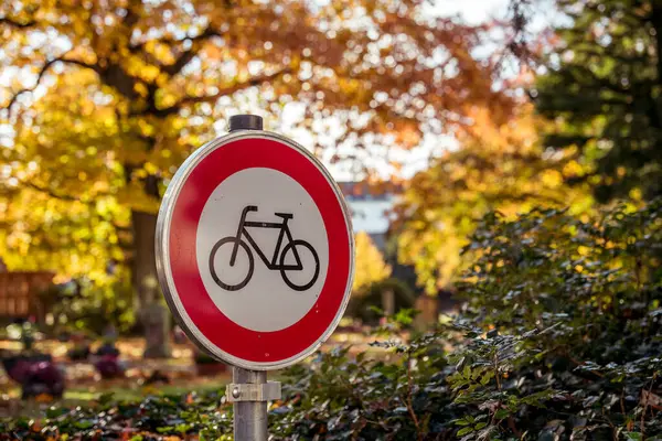 stock image A no cycling sign at the entrance to a cemetery on a sunny fall day.