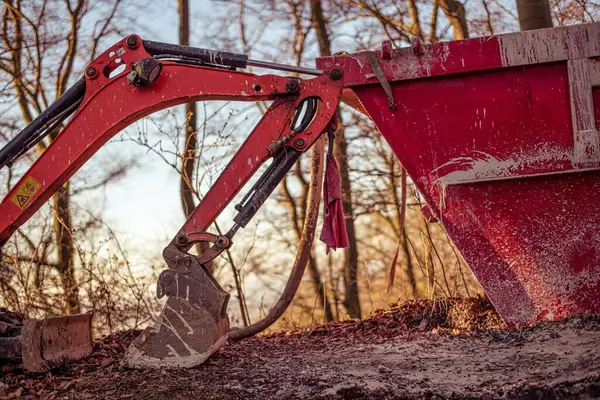 Stock image Excavator and dumpster stand directly in the middle of the forest on a forest road