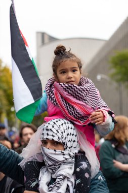 Toronto 'da Gazze Savaşı' na karşı düzenlenen Filistin protestosunda babalarının omuzlarında ağlayan genç bir kız.