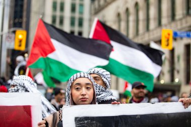 Toronto Ontario Kanada 'lı genç Filistinli kadın Toronto' daki protestoda Gazze 'deki savaşa karşı bir tabela tutuyor. 
