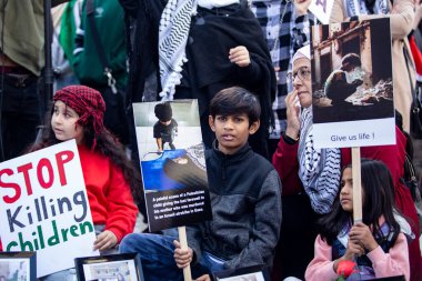 Toronto Ontario Kanada 'daki Gazze' deki savaşa karşı Filistin Protestosu 'nda ellerinde tabela tutan çocuklar