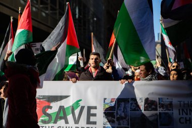 Toronto Ontario Kanada 'da Gazze' deki savaşa karşı Filistin Protestosu 'nun önünde elinde bayrak tutan adam.