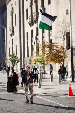 Adam, Toronto 'nun ortasında Filistin' in Gazze 'deki savaşı protesto ettiği sırada Filistin bayrağı tutuyor. 