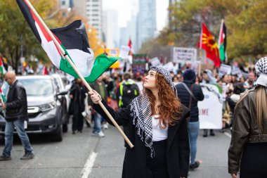 Toronto Ontario Canada 104 2023. Genç kızıl saçlı kadın Toronto 'da Kanada' da Gazze 'deki savaşa karşı Filistin gösterisinde Filistin bayrağı taşıyor.