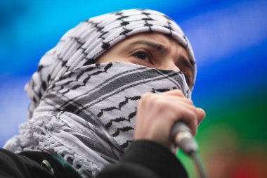 Toronto Ontario Kanada 'lı Filistinli kadın keffiyeh giyen bir grup protestocuya Toronto Kanada' da mikrofon kullanarak sesleniyor