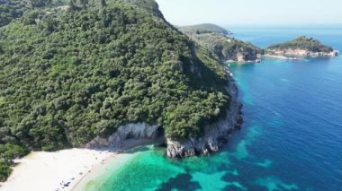 Yunanistan, Korfu, 2023 yazı. Plaj Rovinia, büyüleyici deniz manzarası ve korfu Rovinia plajı dağları, sık ormanlarla kaplı dağlar, derin mavi deniz suyu ve mavi gökyüzü.